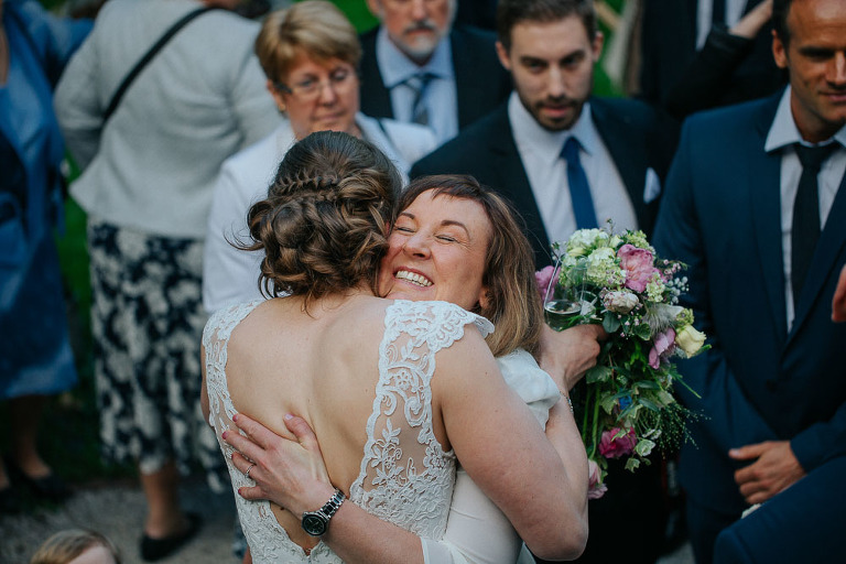 goście składają życzenia w ogrodzie nowożeńcom po ślubie 