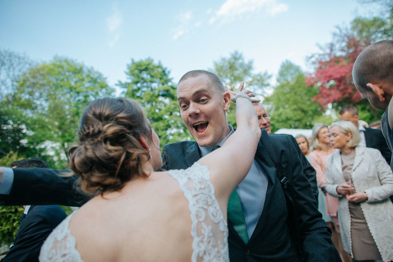 goście składają życzenia nowożeńcom po ślubie