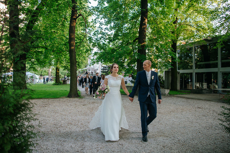 państwo młodzi idą przez ogród na swoje wesele w oranżerii Endorfina Foksal 