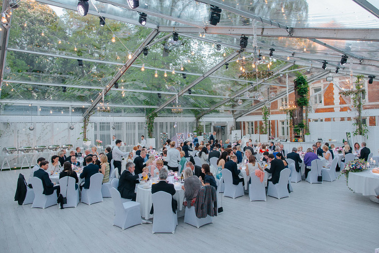 goście siedzący przy stołach podczas wesela w oranżerii Endorfina Foksal 