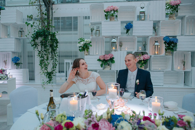 państwo młodzi siedzący przy okrągłym stole na weselu 