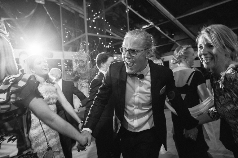 goście tańczą trzymając się za ręce 