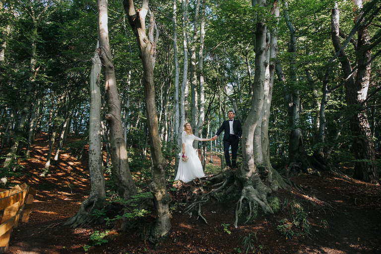 nowożeńcze trzymający się za ręce w lesie 