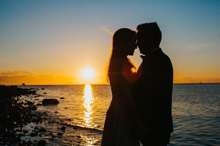 sesja przytulonej para na plaży podczas wschodu słońca nad morzem 