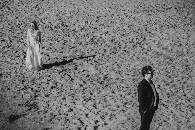 para młoda stojąca oddzielnie podczas sesji na plaży o wschodzie słońca 