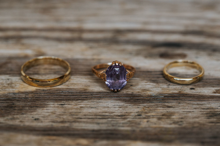 obrączki i pierścionek zaręczynowy na drewnianej desce 