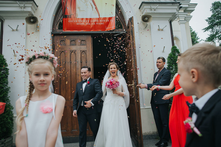 Para młoda obsypana kwiatami na wyjście z kościoła 