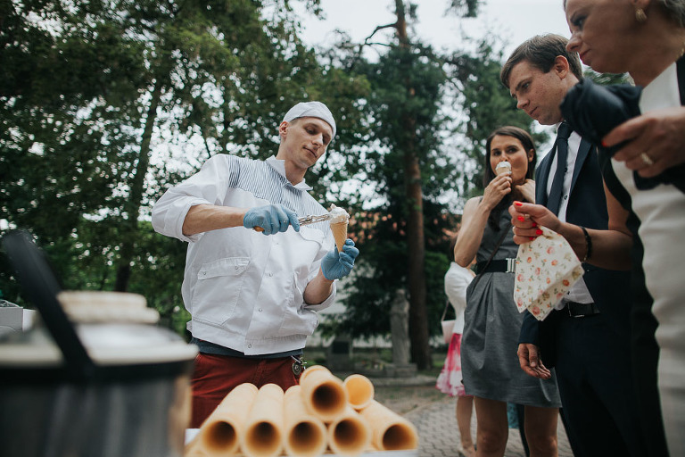 lodziarz serwuje lody gościom weselnym przed kościołem 