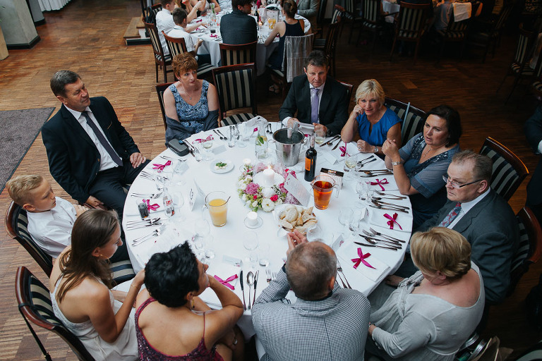 goście siedzący przy stole podczas wesela