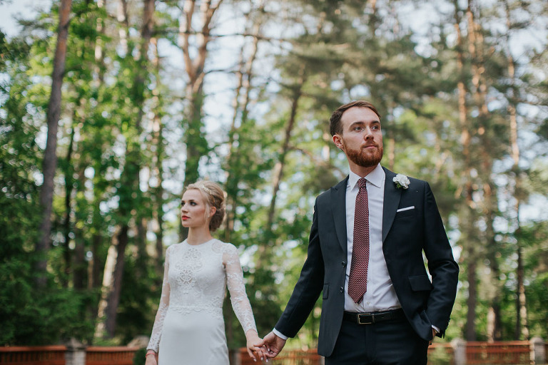 nowożeńcy podczas sesji na tle drzew 