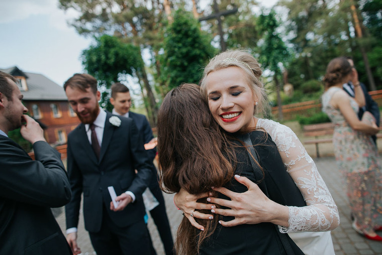 uśmiechnięta panna młoda przytula gościu podczas życzeń