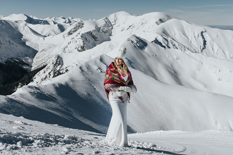 zimowy portret panny młodej stojącej na tle gór 