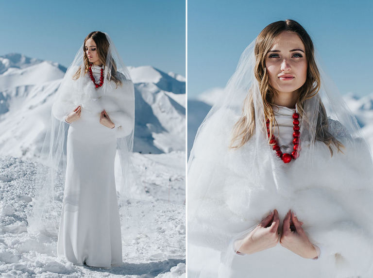 zimowa panna młoda w czerwonych koralach pozująca na tle gór 