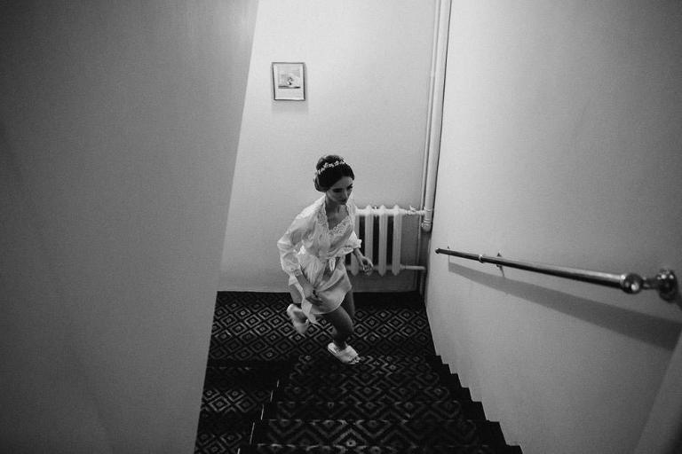 biegnąca po schodach panna młoda przed zimowym ślubem 