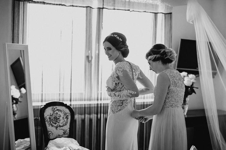 zapinanie sukienki przez świadkową w trakcie przygotowań 