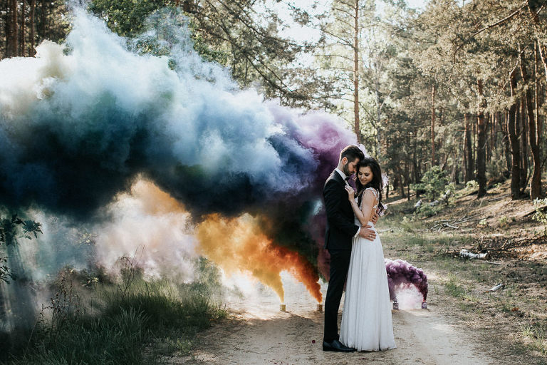 przytulona para podczas sesji ślubnej z kolorowym dymem 