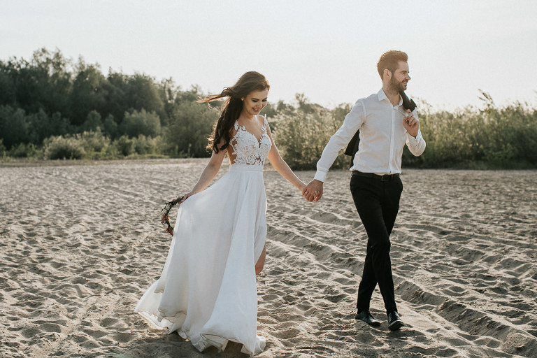 para ślubna idzie po plaży
