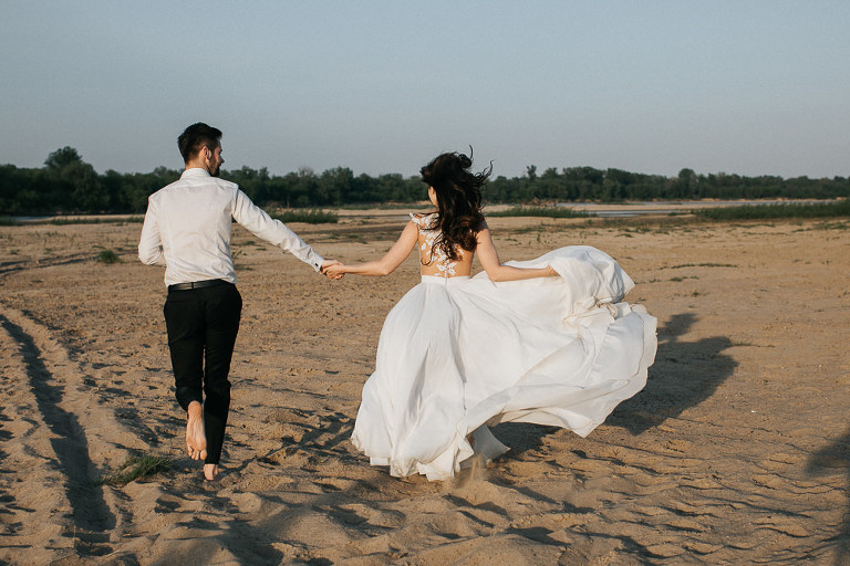 biegnąca para ślubna po plaży podczas pleneru ślubnego