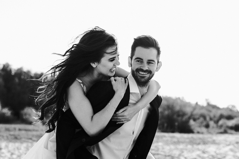 uśmiechnięta para ślubna podczas pleneru na plaży 