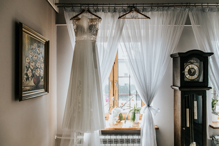 sukienka pani młodej wisząca na oknie