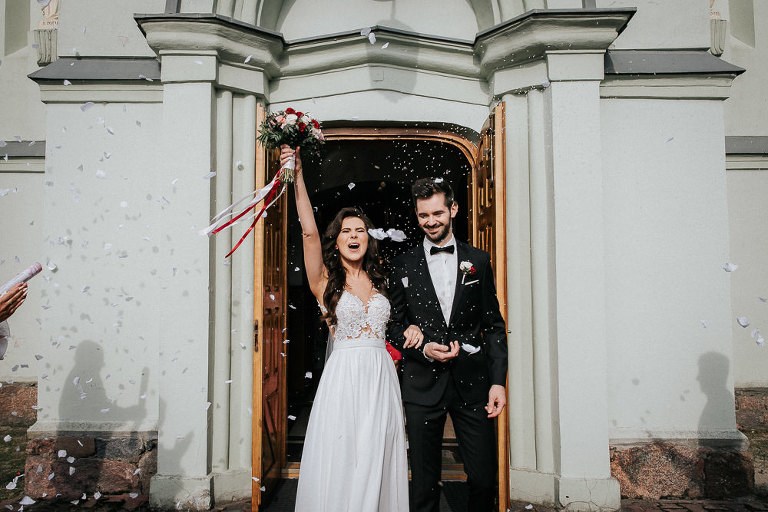 para młoda obrzucona ryżem pod kościołem 