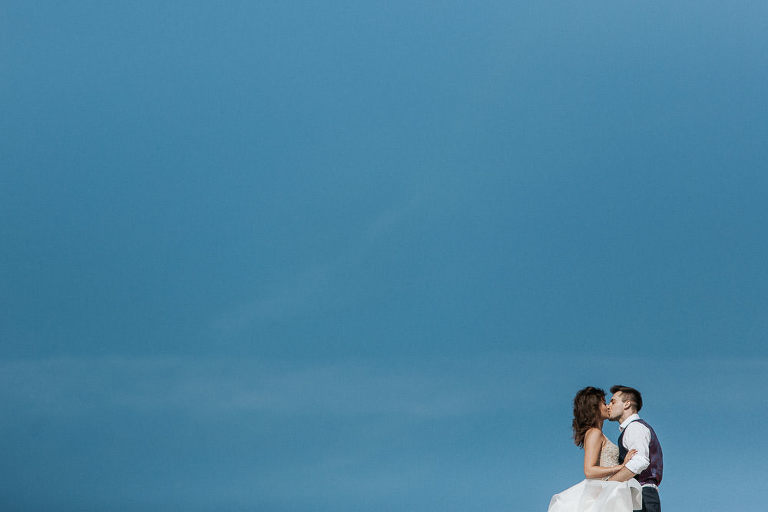 fotografia ślubna nad morzem pary na tle niebieskiego nieba