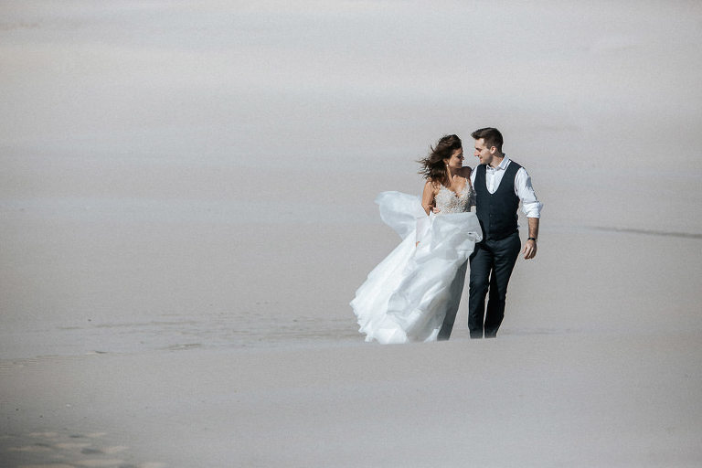 sesja ślubna nad morzem Łeba przytulona para idzie plażą