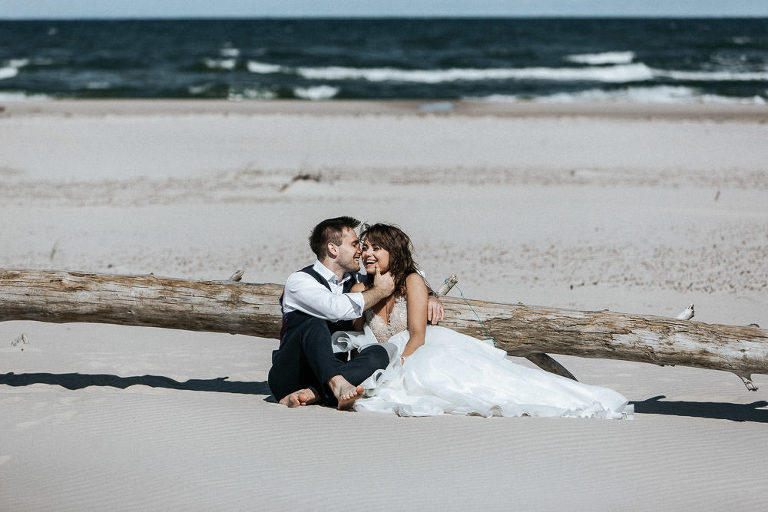 przytulona para ślubna podczas sesji na plaży w tle morze bałtyckie 