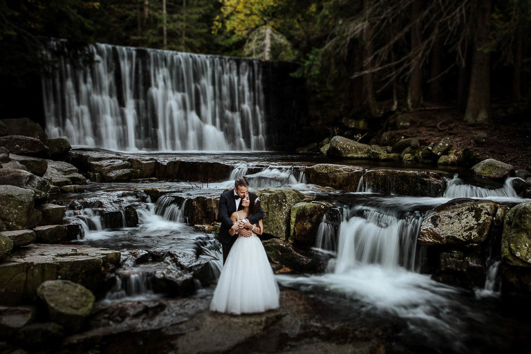 para ślubna pozująca na tle wodospadu 