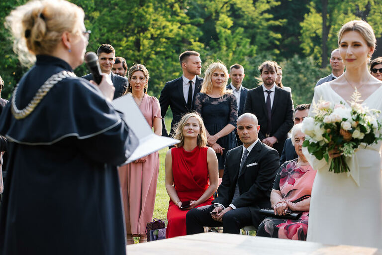 goście obserwują ślub plenerowy 