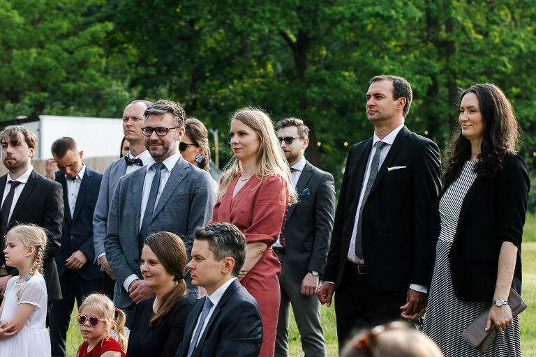 goście na ślubie obserwują ślub plenerowy