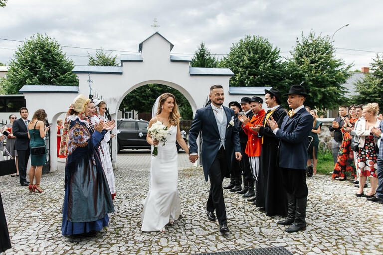 Państwo młodzi idą przez szpaler do cerkwi 